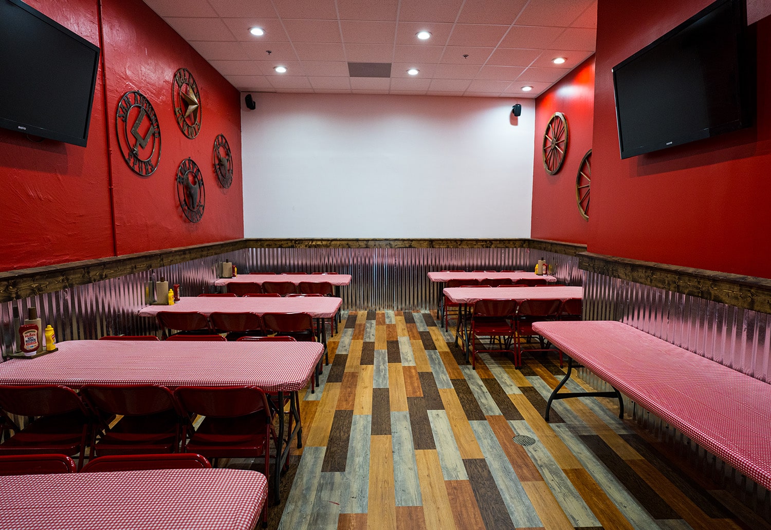 Wing Barn dining room with red chairs and corrugated metal wainscoting