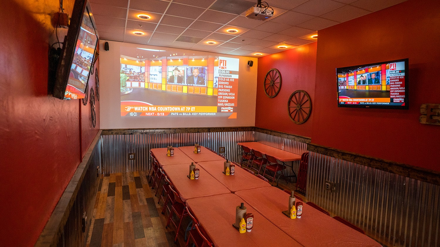 Wing Barn party room with a projector screen showing a sports broadcast