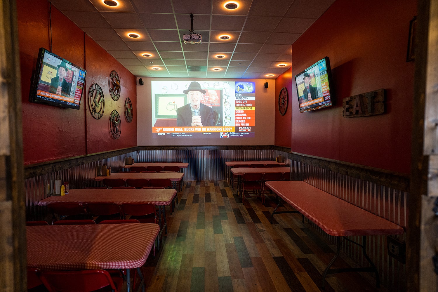 Wing Barn party room with a projector screen showing a sports broadcast