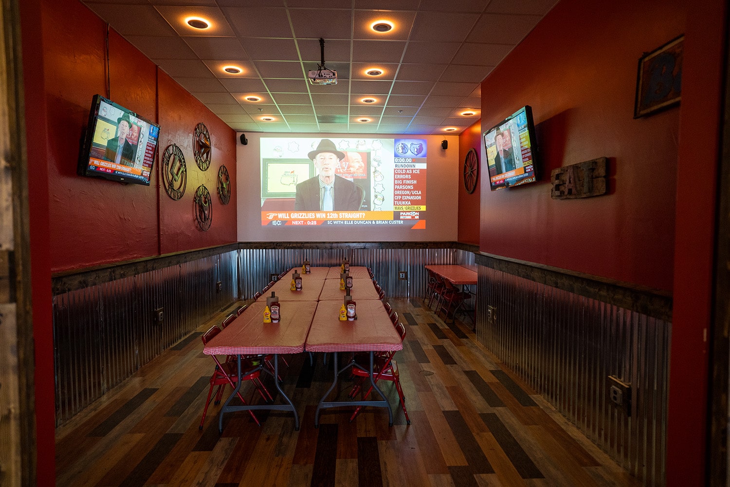Wing Barn party room with a projector screen showing a sports broadcast