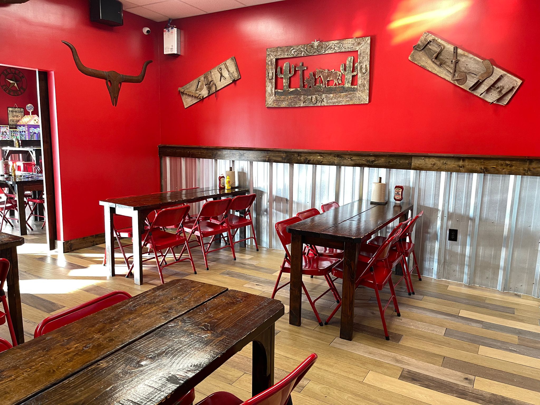 Wing Barn dining room with red walls and Western-themed wall decor