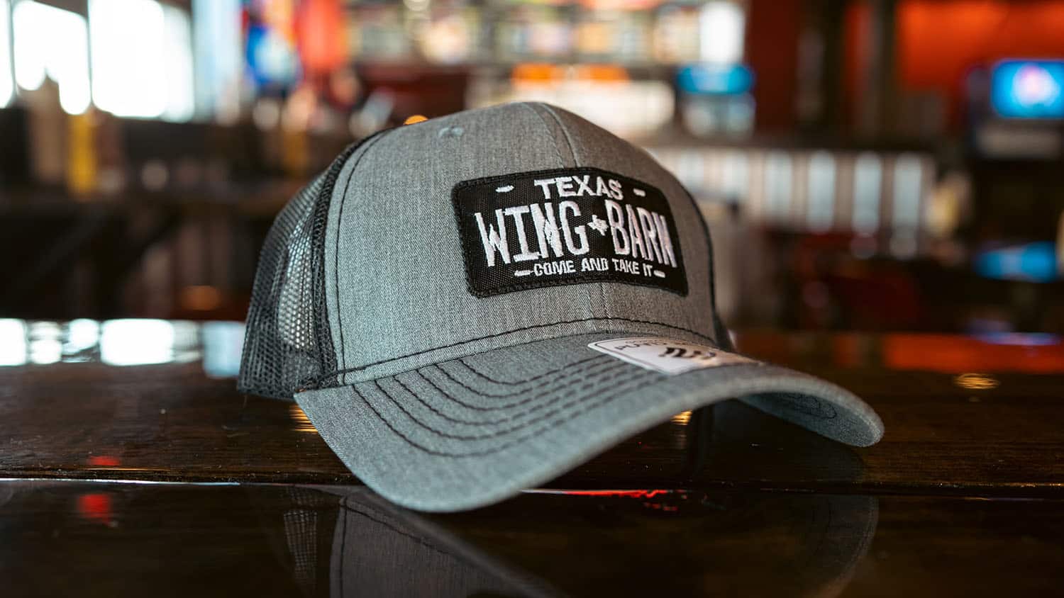 Gray Wing Barn trucker cap with a "Texas Wing Barn, Come and Take It" patch