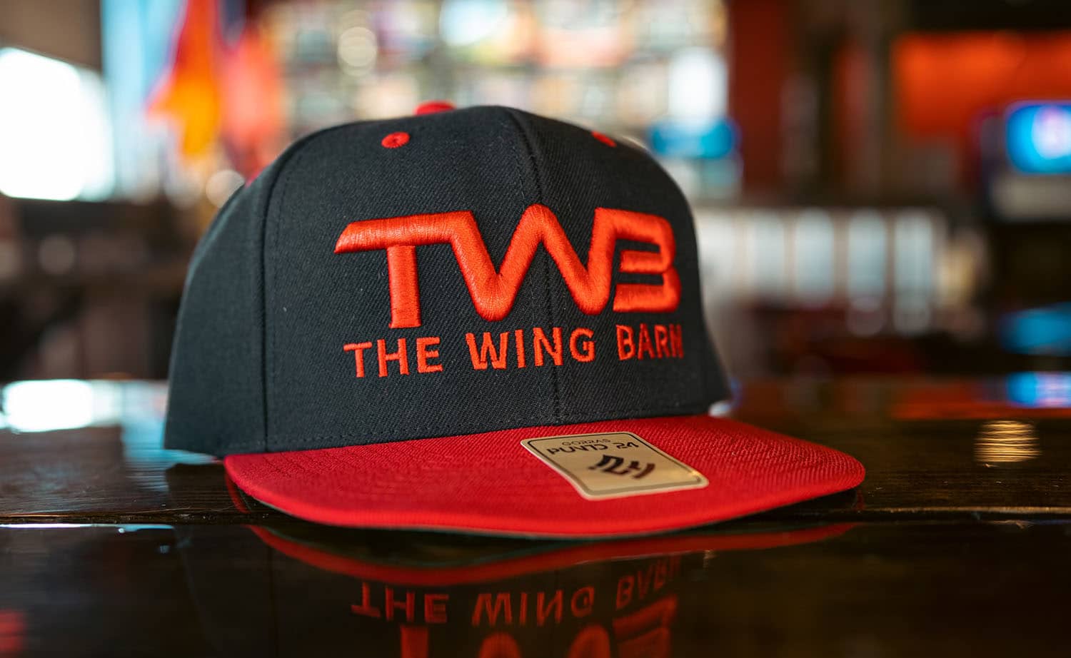 Black and red cap embroidered "TWB The Wing Barn"